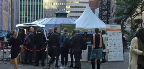 A group of people queing at a CreditSmart stand outside