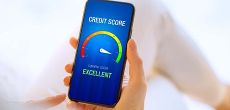 A person holding their phone showing an excellent credit score on the screen